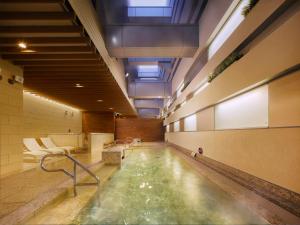 een zwembad in een fitnessruimte met een zwembad bij Villa Fontaine Grand Tokyo Ariake in Tokyo