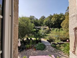 a view of a garden from a window at Le Moulin de Pensol in Pensol