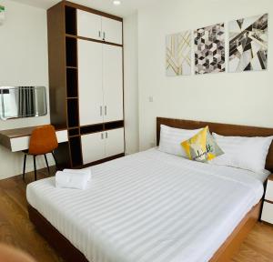 ein Schlafzimmer mit einem großen Bett und einem Stuhl in der Unterkunft Asahi Luxstay - D'el Dorado Apartment in Hanoi