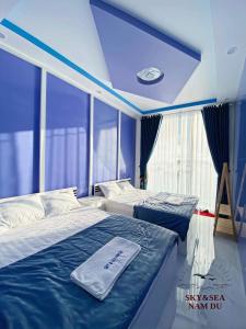 two beds in a room with a blue ceiling at SKY & SEA NAM DU in Nam Du