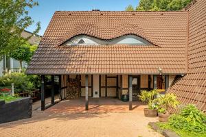 a house with a red roof with a window at Apartment am Bullerbach Deister in Barsinghausen