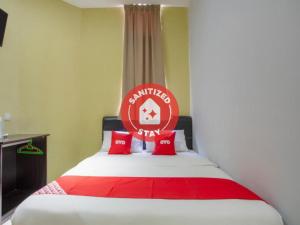 a bedroom with a red and white bed with red pillows at Lodge 37 in Ranau