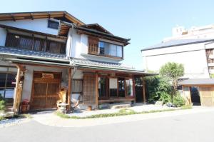 Neyagawa的住宿－Yadokari Osaka，前面有一只狗的亚洲房屋