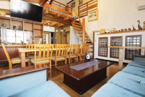 a living room with a couch and a table at Yadokari Osaka in Neyagawa