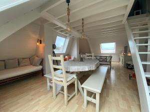 ein Esszimmer mit einem Tisch, Stühlen und einem Sofa in der Unterkunft Appartement Vue Mer - Cabourg - Normandie in Cabourg