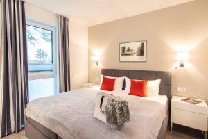 a bedroom with a bed with orange pillows and a window at Appartement "Haffglück" mit Penthouseflair - Oase am Haff in Garz