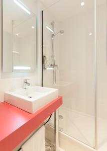 y baño blanco con lavabo y ducha. en ibis Styles Bordeaux Saint Médard, en Saint-Médard-en-Jalles