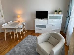 a living room with a table and a chair and a tv at Appartement großzügiges 2-Zimmer-Appartement im Zentrum von Potsdam direkt an der Havel in Potsdam