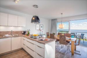 a kitchen and dining room with a view of the ocean at Appartement "Kliffkante" mit Penthouseflair - Oase am Haff in Garz