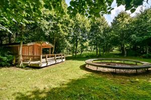 un jardín con un estanque y una cabaña de madera en Emda Country living close to Legoland en Billund