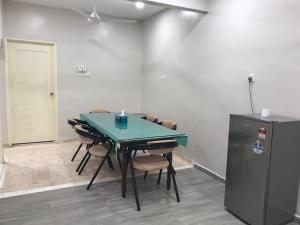 uma sala de conferências com uma mesa e cadeiras e um frigorífico em Homestay Melaka Baitul Saadah em Malaca