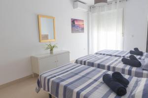 2 łóżka w pokoju z niebiesko-białymi paskami w obiekcie Casa Elena - Cabo de Gata w mieście Carboneras