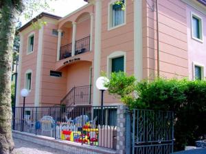 un edificio rosa con una valla delante en Hotel Villa Grazia, en Cesenatico