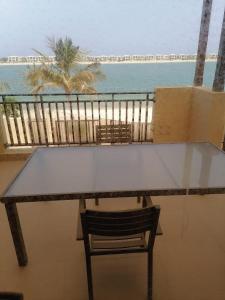 a table and a chair on a balcony with the ocean at Royal Sea View Villa with Private Pool in Ras al Khaimah