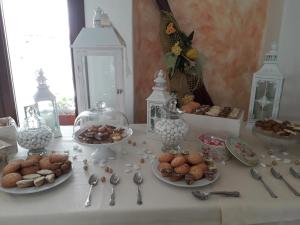 a table with spoons and plates of food on it at Hotel Resort Nuraghe Arvu in Cala Gonone