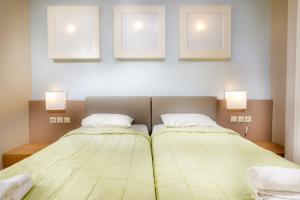dos camas sentadas una al lado de la otra en un dormitorio en Sovereign Beach Hotel, en Kardamaina
