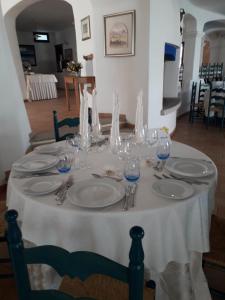 a table with plates and glasses on top of it at Hotel Resort Nuraghe Arvu in Cala Gonone