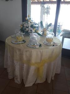 a table with a white table cloth and cakes on it at Hotel Resort Nuraghe Arvu in Cala Gonone