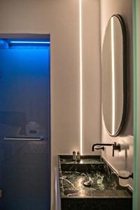 bagno con lavandino e specchio di Levantes Luxury Suites II a Città di Tinos