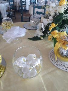 a table with glasses and flowers on top of it at Hotel Resort Nuraghe Arvu in Cala Gonone