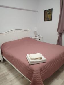 a bed with two towels on top of it at Apartament Plaja Golful Pescarilor in Constanţa