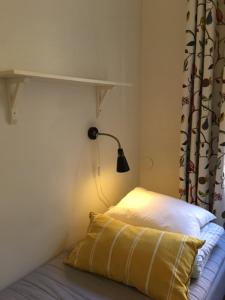 
a bedroom with a bed and a lamp on the wall at Castanea Old Town Hostel in Stockholm
