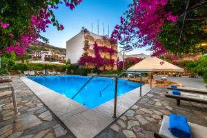 a swimming pool in a courtyard with a building at Skala Hotel in Skala