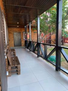 a porch of a house with a bench at Мини-отель Sunrise-Bugaz in Zatoka