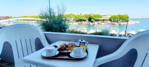 a plate of food on a table with a view of the water at Hotel Carol in Grado