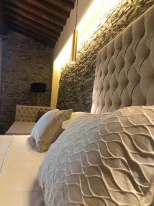 una camera da letto con un grande letto con una grande testiera di Calidario Terme Etrusche a Venturina Terme