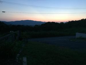a sunset over a road with mountains in the background at Shimaotoya in Iriomote