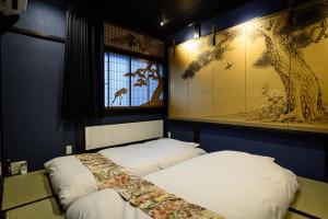 2 letti in una camera con dipinti alle pareti di Gojozaka Samurai Machiya a Kyoto Altre 37 foto