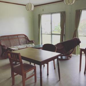 salon ze stołem, krzesłami i kanapą w obiekcie Shimaotoya w mieście Iriomote