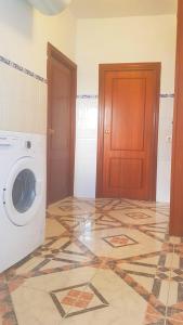 a laundry room with a washing machine and a tile floor at Casa Algarabía in Sanlúcar de Barrameda