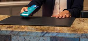 a person holding a cell phone on top of a counter at Skala Hotel in Skala