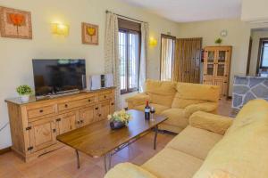 uma sala de estar com um sofá e uma mesa em Casa Rural El Chaparro em El Chorro