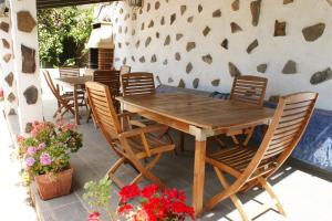 drewniany stół i krzesła na patio z kwiatami w obiekcie Apartamentos Nelly w mieście Valle Gran Rey