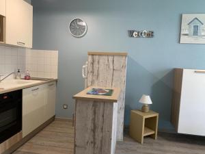 a kitchen with a wooden door in the corner at Les Sables d'Or in Équemauville