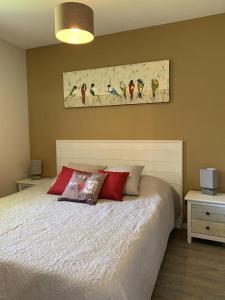 a bedroom with a bed and a painting on the wall at Les Sables d'Or in Équemauville