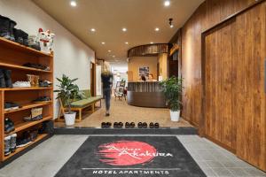 a woman walking through a lobby with a rug on the floor at The Address Akakura in Myoko