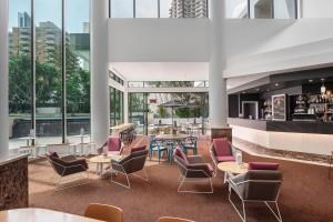 a lobby with tables and chairs and windows at Mantra Legends Hotel in Gold Coast