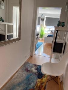 City Studio 2 في برمرهافن: غرفة معيشة مع كرسي أبيض ومرآة