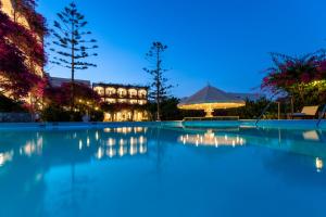 a swimming pool at night with a building in the background at Skala Hotel in Skala