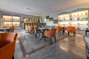 a restaurant with tables and chairs in a room at Skala Hotel in Skala