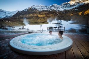 dos personas en un jacuzzi en las montañas en Hotel Restaurant Rosmarie, en Pfelders