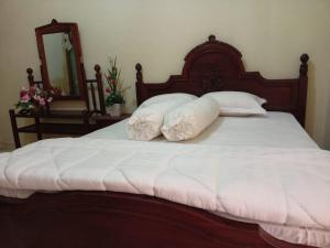- un lit avec des draps et des oreillers blancs dans l'établissement FERMANA HOMESTAY, à Painan