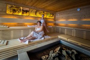 Uma mulher está sentada numa sauna. em Hotel Restaurant Rosmarie em Pfelders