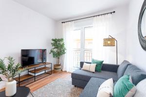 uma sala de estar com um sofá azul e uma televisão em Genteel Home Encarnación em Sevilha