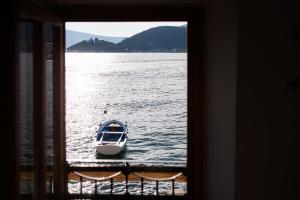 a small boat in the water through a window at Apartments Villa Serventi in Tivat