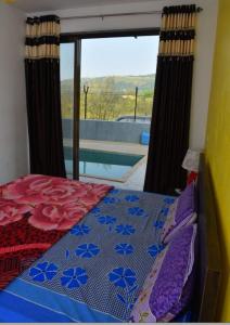 een slaapkamer met een bed en uitzicht op een zwembad bij Killer Villa 3 BHK in Lonavala